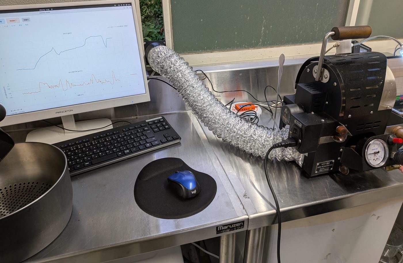 WE×SUJI Mini Roaster の排気口にアルミダクトを直結し、窓の排気ファンへ送っている様子。左の PC にデスクトップアプリのグラフ